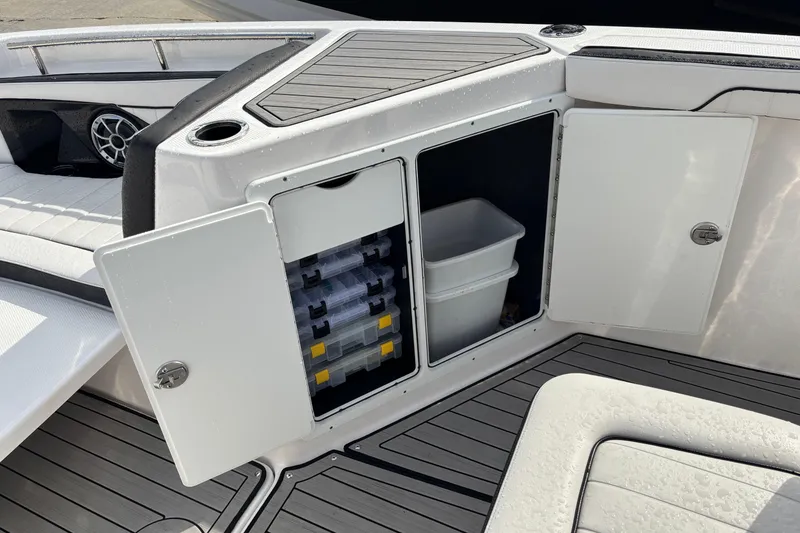 Slide: The Image of 2021 Yamaha Boats 255 FSH Sport E storage compartment with tackle boxes and bin. - 26