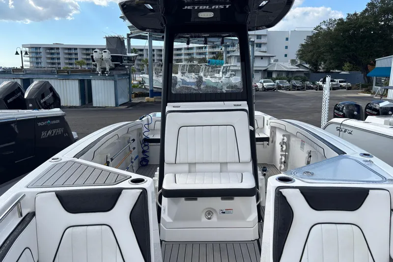 Slide: The Image of 2021 Yamaha Boats 255 FSH Sport E interior with seating and console, docked at marina. - 29