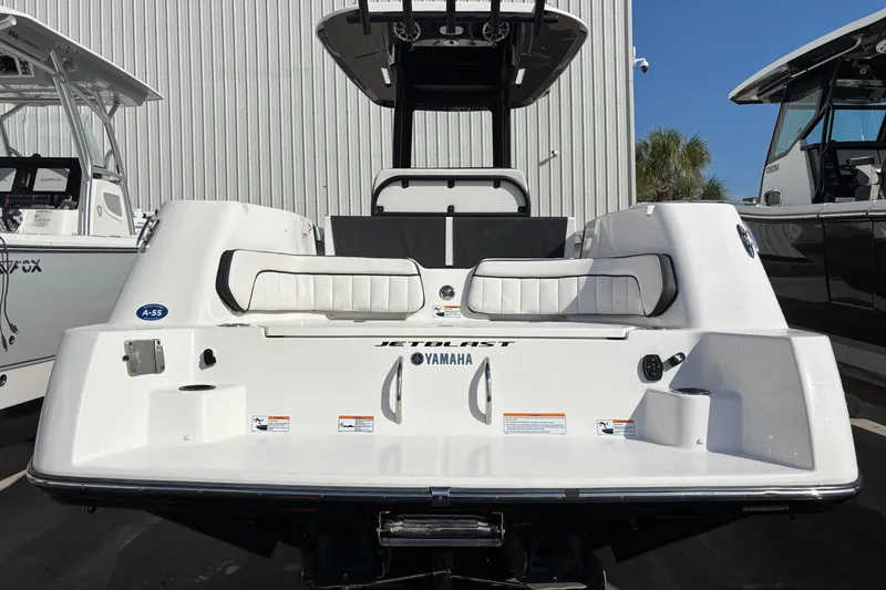 Slide: The Image of 2021 Yamaha Boats 255 FSH Sport E, rear view, docked, showcasing seating and design. - 3