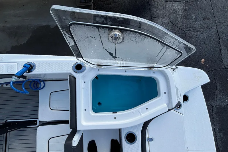 Slide: The Image of 2021 Yamaha Boats 255 FSH Sport E livewell with open lid and blue interior. - 34