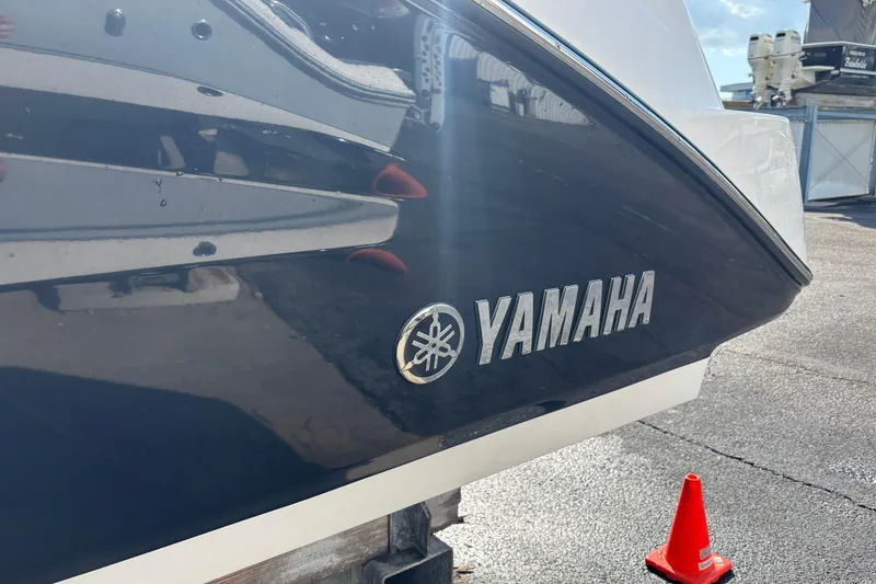 Slide: The Image of 2021 Yamaha Boats 255 FSH Sport E, side view with logo, docked outdoors. - 41