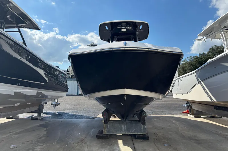 Slide: The Image of 2021 Yamaha Boats 255 FSH Sport E, black hull, docked between two boats. - 7