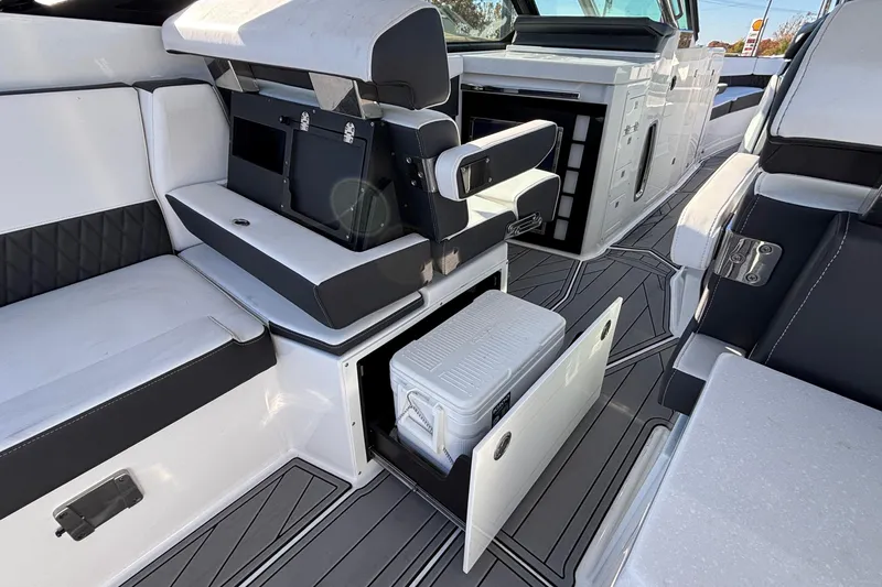 Slide: The Image of 2023 Monterey 385SS Super Sport boat interior with seating, storage, and cooler. - 66