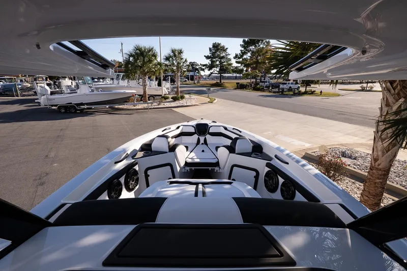 Slide: The Image of 2026 Sunsation 32 CCX boat with sleek design, docked near palm trees and other boats. - 16