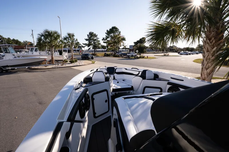 Slide: The Image of 2026 Sunsation 32 CCX boat interior with sleek seating, parked near palm trees. - 17