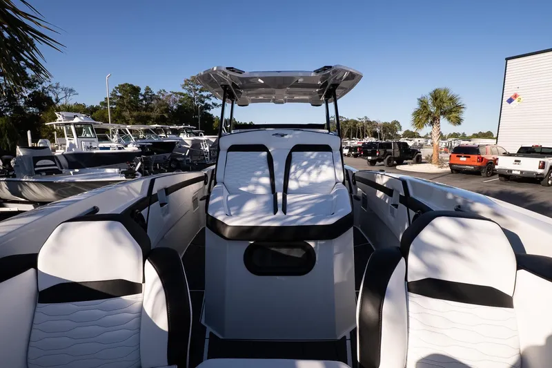 Slide: The Image of 2026 Sunsation 32 CCX boat with sleek white seating and modern design in a marina setting. - 23