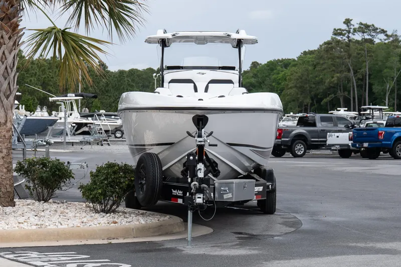 Slide: The Image of 2026 Sunsation 32 CCX boat on trailer in parking lot, surrounded by trees and vehicles. - 27