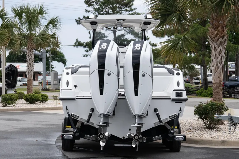 Slide: The Image of 2026 Sunsation 32 CCX boat with dual engines, parked near palm trees. - 29
