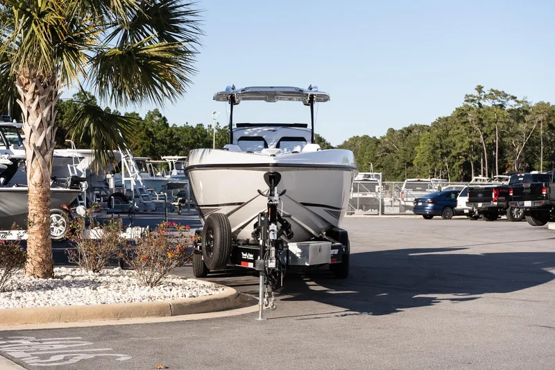 Slide: The Image of 2026 Sunsation 32 CCX boat on trailer in parking lot, surrounded by trees and vehicles. - 3