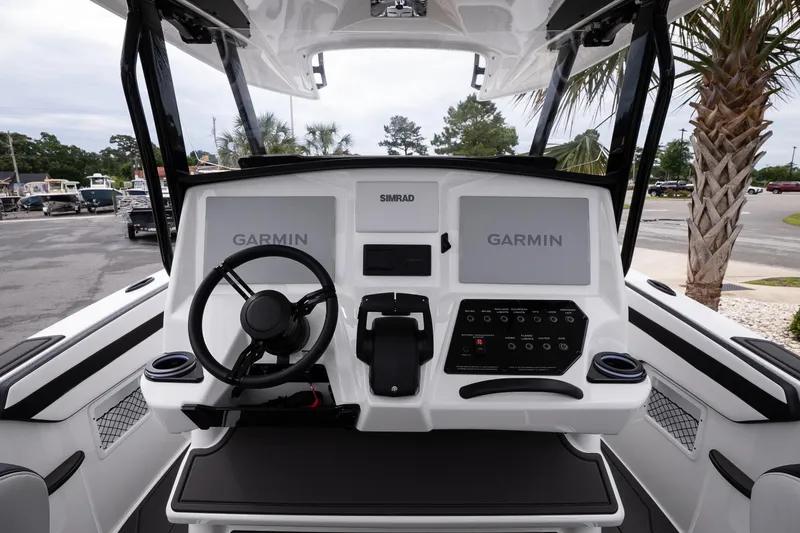 Slide: The Image of Cockpit of 2026 Sunsation 32 CCX boat with Garmin navigation displays and steering wheel. - 32