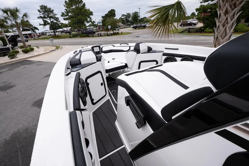Slide: The Image of 2026 Sunsation 32 CCX boat interior with sleek white and black seating, parked outdoors. - 33