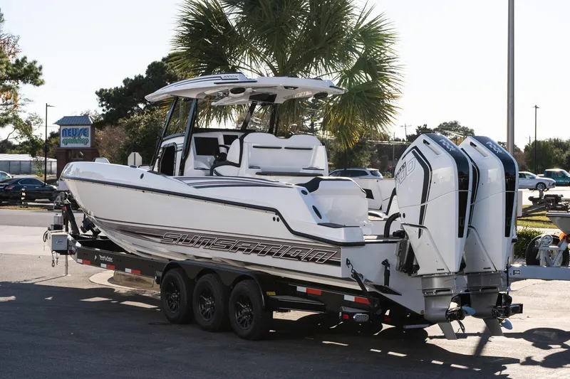 Slide: The Image of 2026 Sunsation 32 CCX boat on trailer, featuring dual outboard engines, parked outdoors. - 4