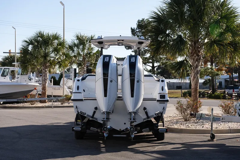 Slide: The Image of 2026 Sunsation 32 CCX boat with dual engines, parked near palm trees. - 5