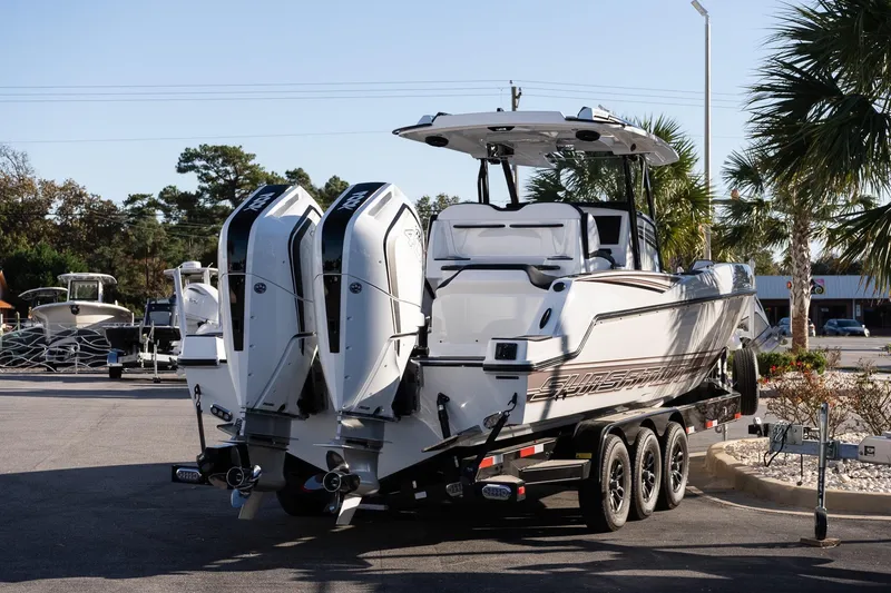 Slide: The Image of 2026 Sunsation 32 CCX boat on trailer, featuring dual outboard engines, parked outdoors. - 6