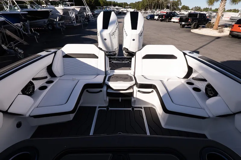 Slide: The Image of 2026 Sunsation 32 CCX boat interior with white seating and twin engines in a marina setting. - 9