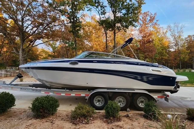 The Image of 2008 Crownline 270 BR boat on trailer, surrounded by autumn trees. - 0