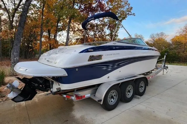 Slide: The Image of 2008 Crownline 270 BR boat on a trailer, parked outdoors in a wooded area. - 1