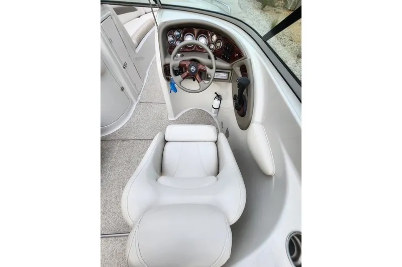 Slide: The Image of 2008 Crownline 270 BR boat cockpit with steering wheel and white captain's chair. - 11