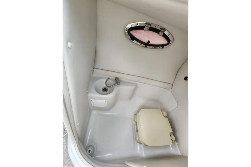 Slide: The Image of 2008 Crownline 270 BR boat interior with compact bathroom and porthole window. - 21