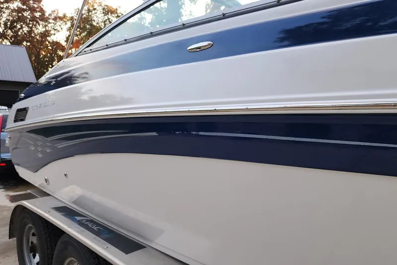 Slide: The Image of 2008 Crownline 270 BR boat with sleek blue and white design on a trailer. - 8