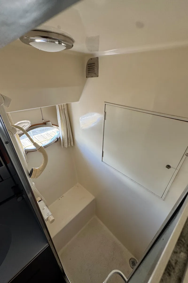 Slide: The Image of Bathroom interior of 1991 Ocean Alexander 46 yacht, featuring compact design and porthole window. - 23