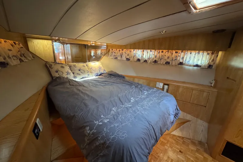 Slide: The Image of Cozy bedroom in 1991 Ocean Alexander 46 yacht with floral curtains and wooden cabinetry. - 26