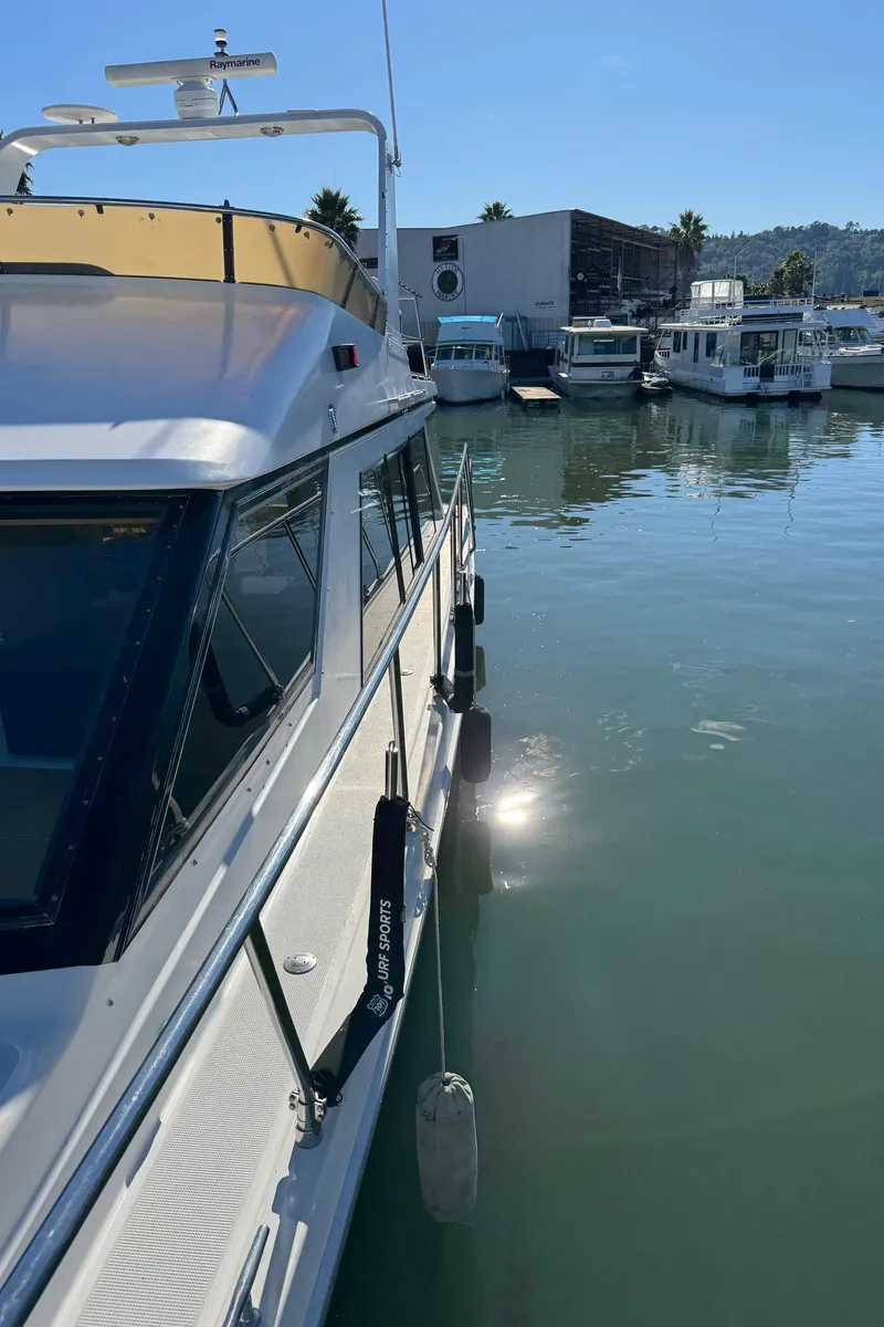 Slide: The Image of 1991 Ocean Alexander 46 yacht docked in a marina under clear blue skies. - 31
