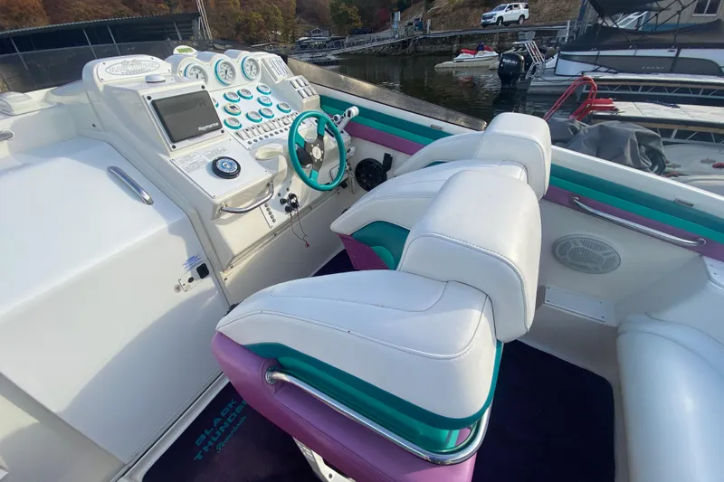 Slide: The Image of Cockpit of 1999 Black Thunder XT 430 SC boat with white and teal seating. - 12