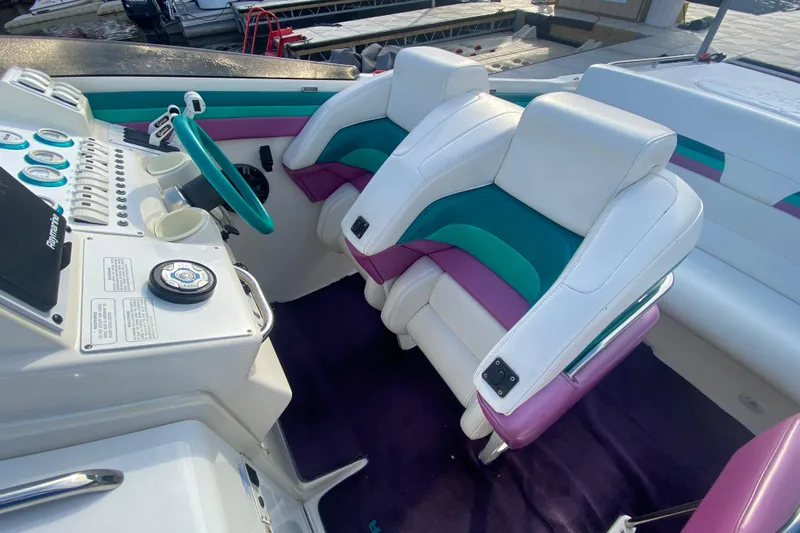 Slide: The Image of Interior of a 1999 Black Thunder XT 430 SC boat with colorful seating and dashboard. - 15