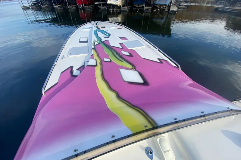 Slide: The Image of 1999 Black Thunder XT 430 SC boat with vibrant pink and yellow design on deck. - 26