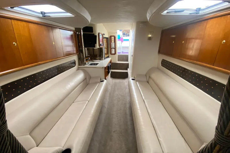Slide: The Image of Luxurious interior of 1999 Black Thunder XT 430 SC boat with plush seating and wood cabinets. - 38