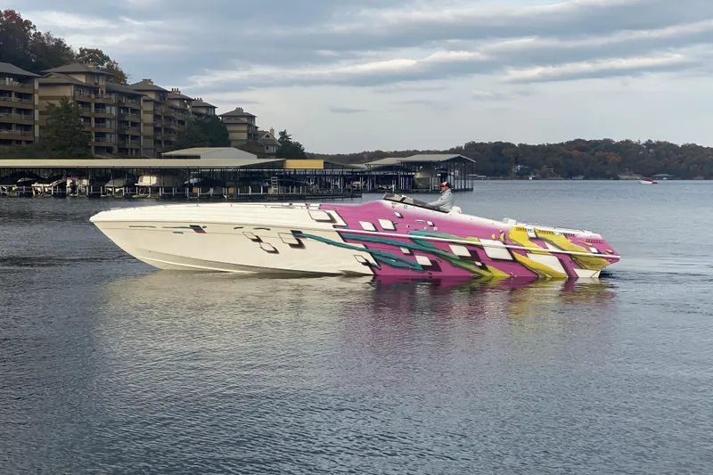 Slide: The Image of 1999 Black Thunder XT 430 SC speedboat with vibrant graphics on a calm lake. - 50
