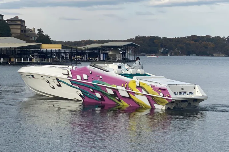 Slide: The Image of 1999 Black Thunder XT 430 SC boat with vibrant graphics on a calm lake. - 51