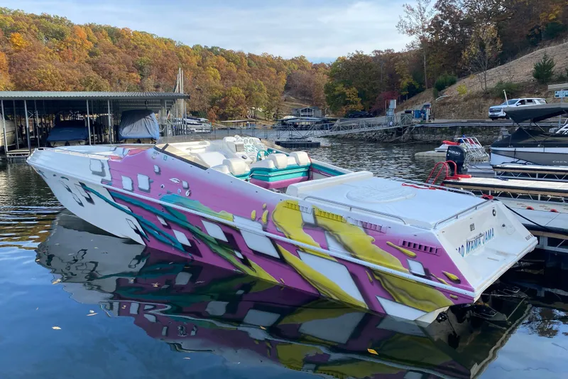 Slide: The Image of Colorful 1999 Black Thunder XT 430 SC speedboat docked on a serene lake. - 6