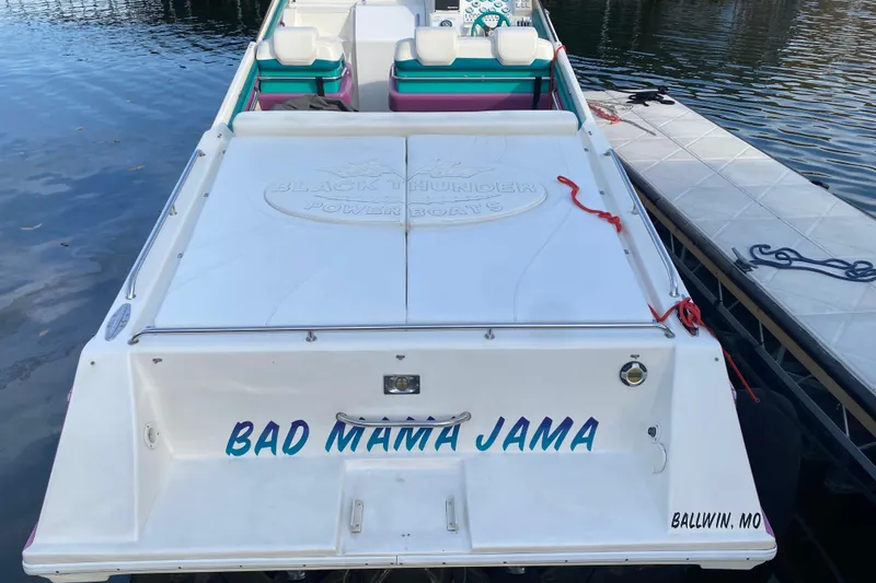 Slide: The Image of 1999 Black Thunder XT 430 SC powerboat named "Bad Mama Jama" docked by the water. - 8