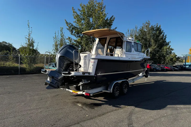 The Image of 2024 Ranger Tugs R-25 boat on trailer, parked outdoors under clear blue sky. - 0