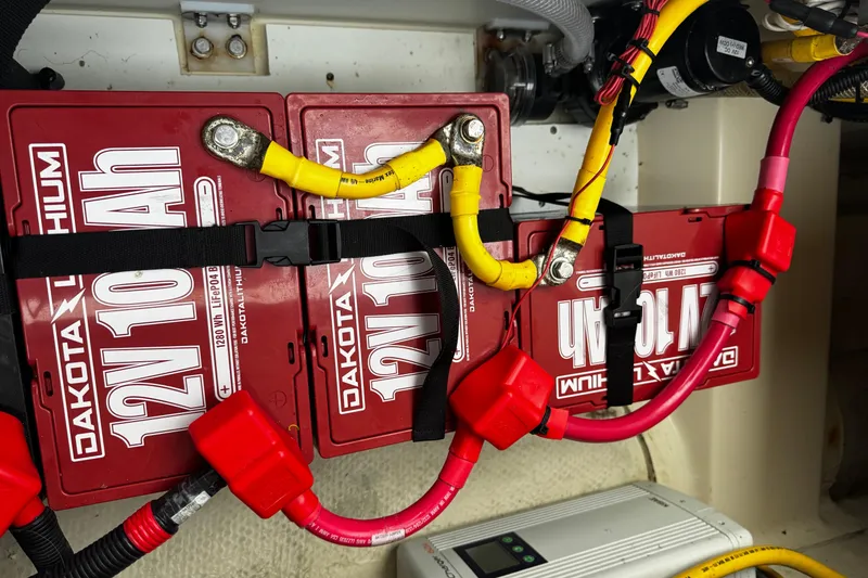 Slide: The Image of 2024 Ranger Tugs R-25 lithium batteries with cables and connectors in engine compartment. - 11