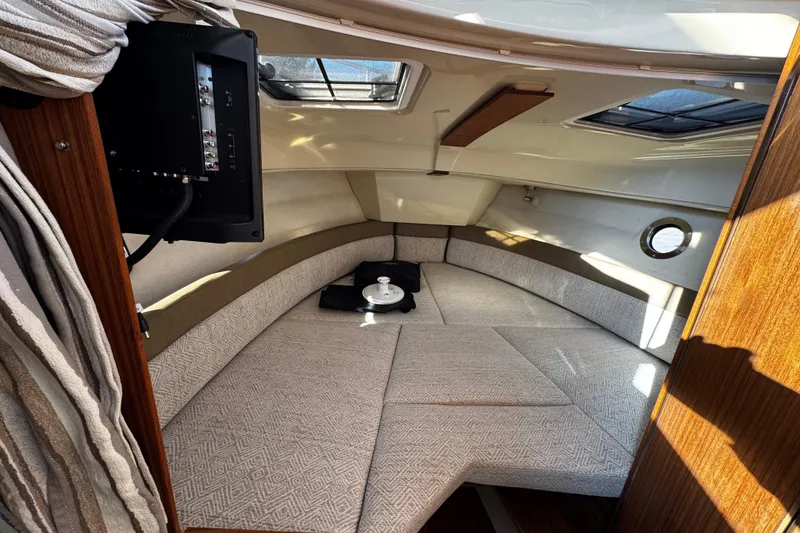 Slide: The Image of 2024 Ranger Tugs R-25 boat on trailer, dark blue hull, parked outdoors. - 4