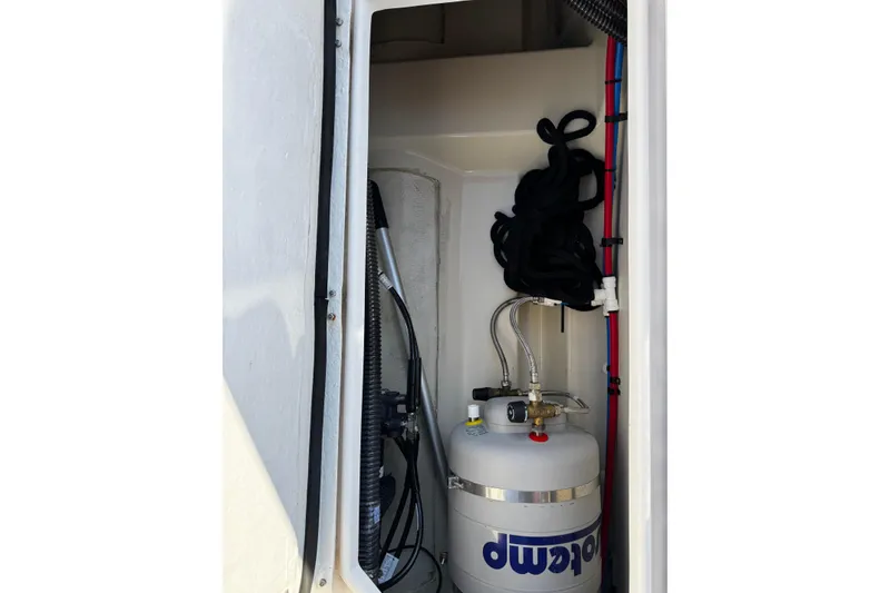 Slide: The Image of Storage compartment in 2024 Ranger Tugs R-25 with propane tank and coiled rope. - 8