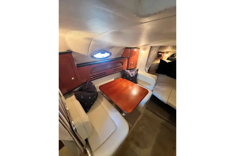 Slide: The Image of Interior of 2005 Sea Ray 280 Sundancer with cozy dining area and wooden cabinetry. - 14