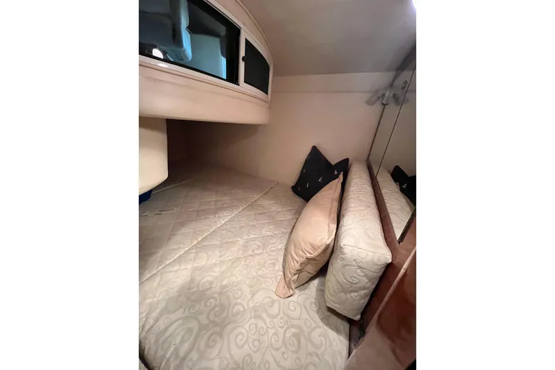 Slide: The Image of Cozy cabin interior of 2005 Sea Ray 280 Sundancer with plush bedding and pillows. - 22