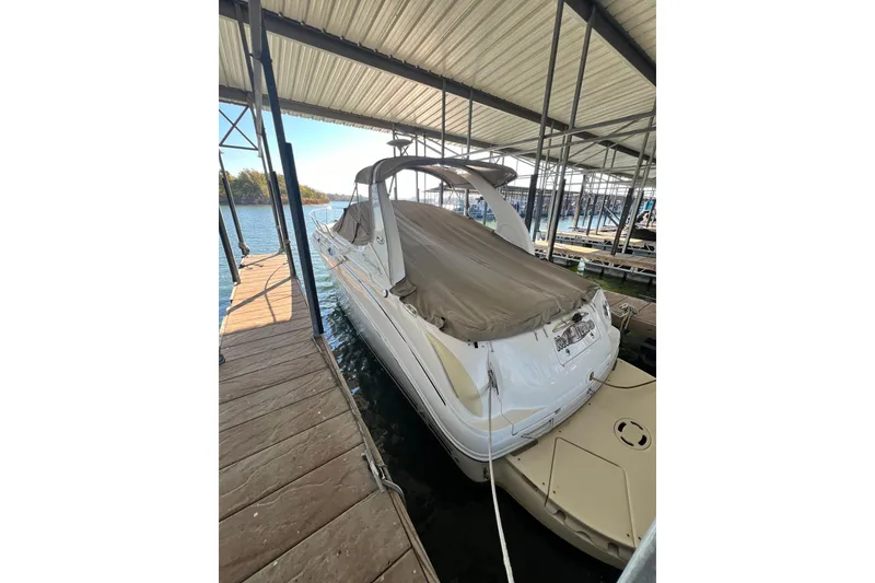 Slide: The Image of 2005 Sea Ray 280 Sundancer boat interior with white seating and storage compartments. - 3