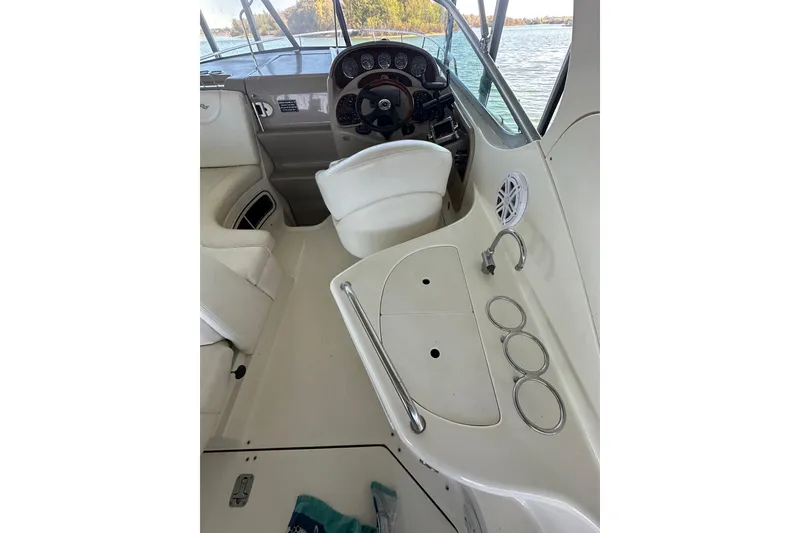 Slide: The Image of 2005 Sea Ray 280 Sundancer interior with white seating and speaker detail. - 7