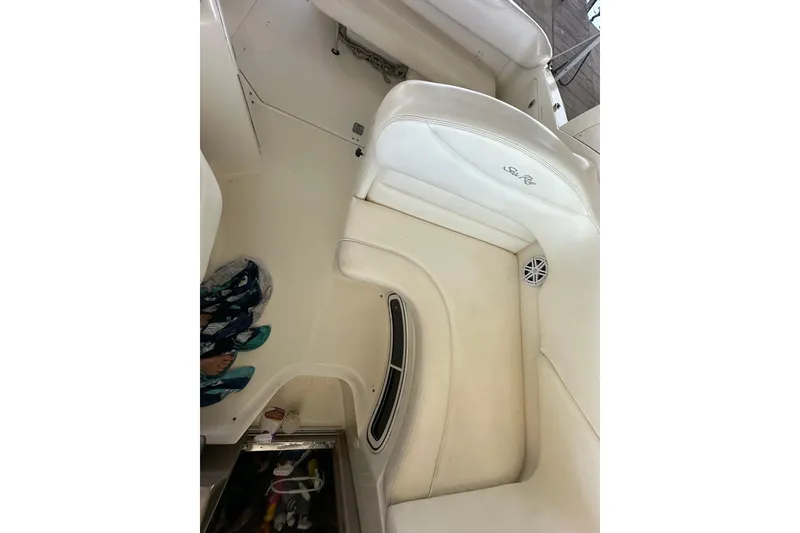 Slide: The Image of 2005 Sea Ray 280 Sundancer helm with gauges, steering wheel, and controls, docked by the water. - 9