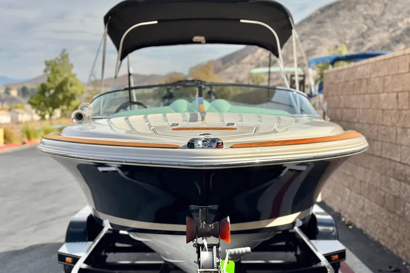 Slide: The Image of 2005 Chris-Craft Speedster boat on trailer, scenic mountain background. - 2