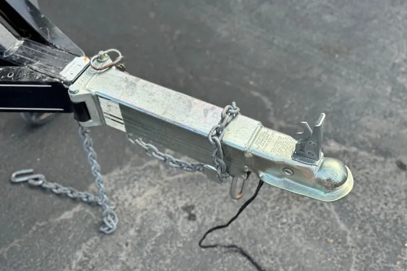 Slide: The Image of Trailer hitch of a 2005 Chris-Craft Speedster with safety chains on asphalt. - 27