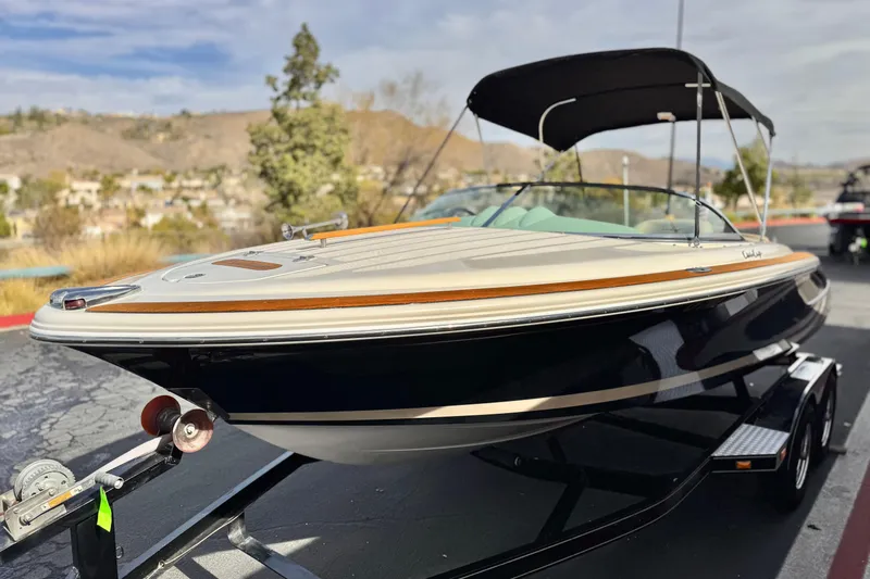 Slide: The Image of 2005 Chris-Craft Speedster boat on trailer, sleek design with black hull and wood accents. - 3