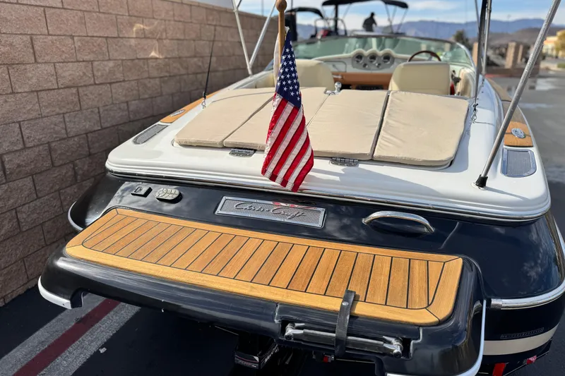 Slide: The Image of 2005 Chris-Craft Speedster boat with American flag, featuring teak deck and luxurious seating. - 6