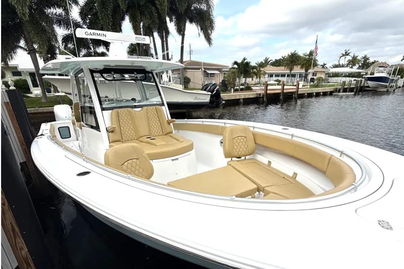 Slide: The Image of 2023 Sportsman Open 352 Center Console boat docked by waterfront homes. - 4