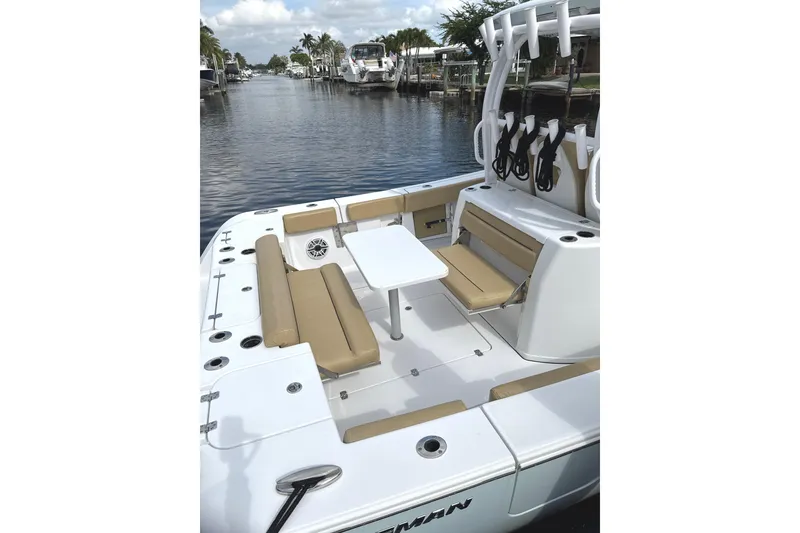 Slide: The Image of 2023 Sportsman Open 352 Center Console boat with seating and table on a calm waterway. - 48